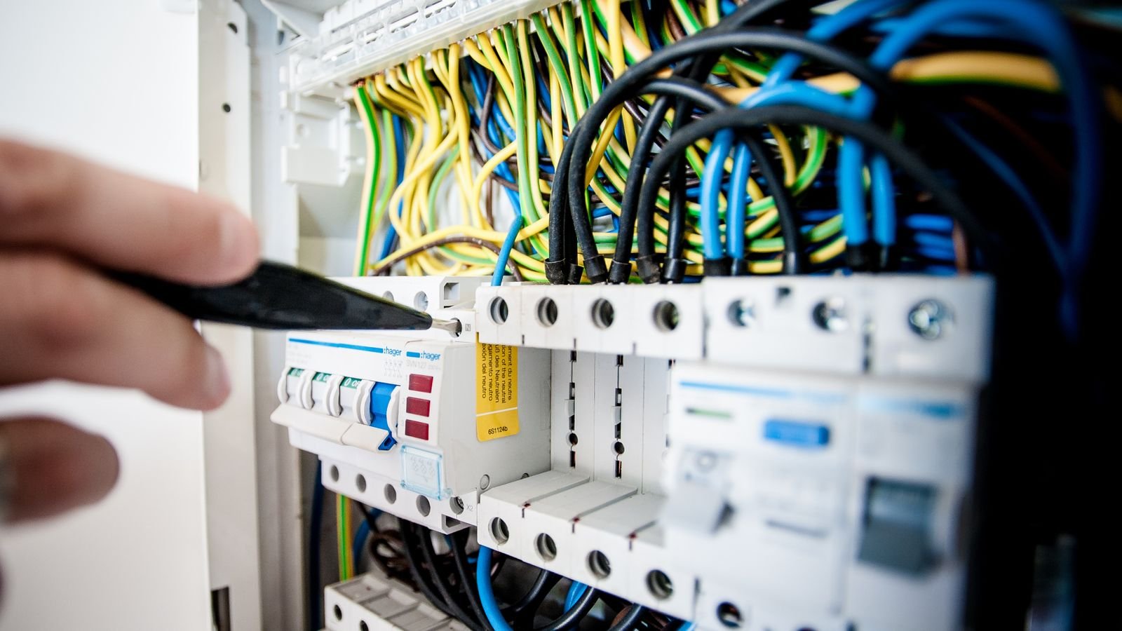 Technician wiring an industrial electrical panel where isolated remote I/O, power and communications must be separated