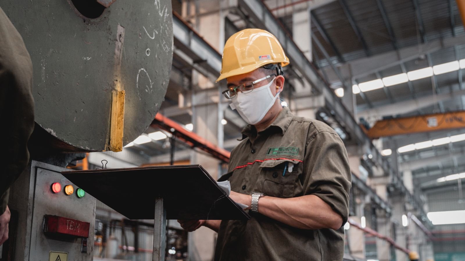 Factory technician reviewing machinery documentation during Titania device identity and revision verification